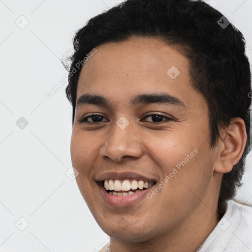 Joyful latino young-adult male with short  black hair and brown eyes