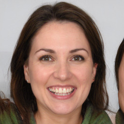 Joyful white adult female with long  brown hair and brown eyes