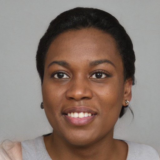Joyful black young-adult female with short  black hair and brown eyes