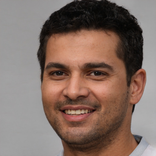 Joyful white young-adult male with short  black hair and brown eyes
