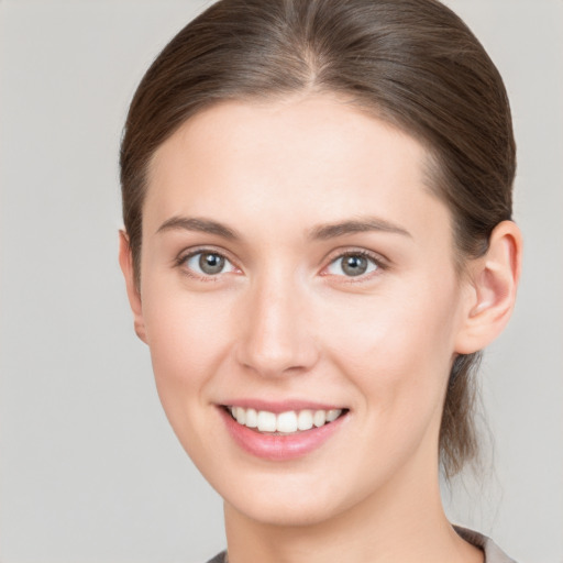 Joyful white young-adult female with medium  brown hair and grey eyes