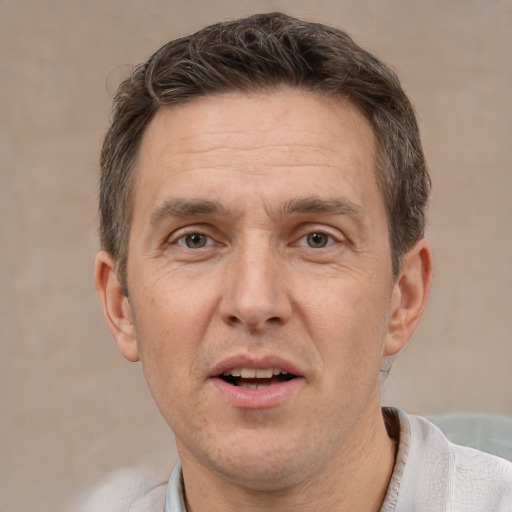 Joyful white adult male with short  brown hair and grey eyes