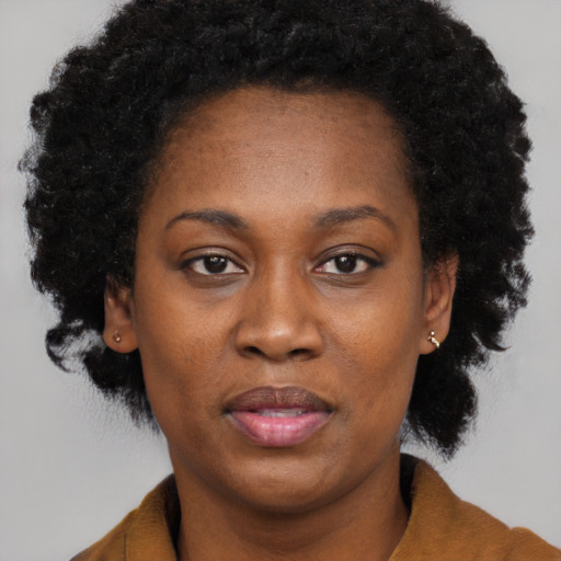 Joyful black adult female with short  black hair and brown eyes