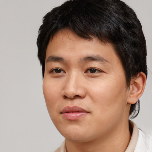 Joyful asian young-adult male with short  brown hair and brown eyes
