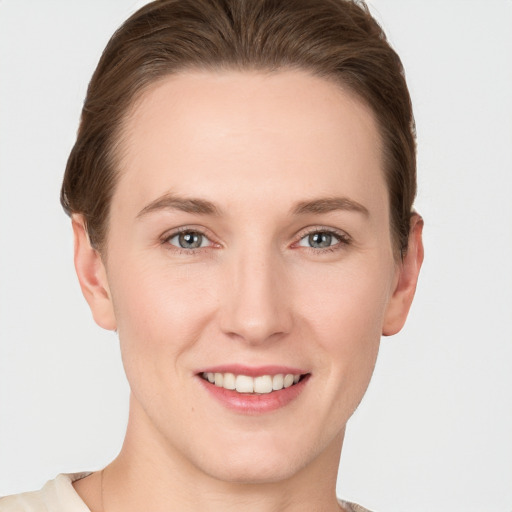 Joyful white young-adult female with short  brown hair and grey eyes