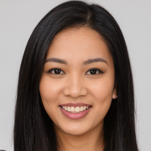 Joyful latino young-adult female with long  brown hair and brown eyes