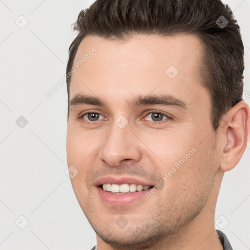 Joyful white young-adult male with short  brown hair and brown eyes