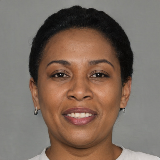 Joyful black adult female with short  brown hair and brown eyes