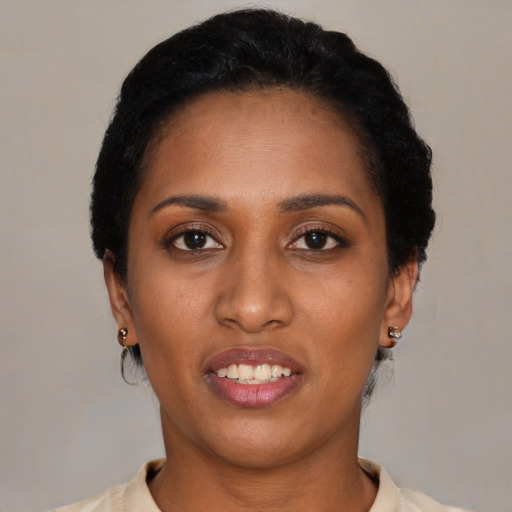 Joyful black young-adult female with short  black hair and brown eyes