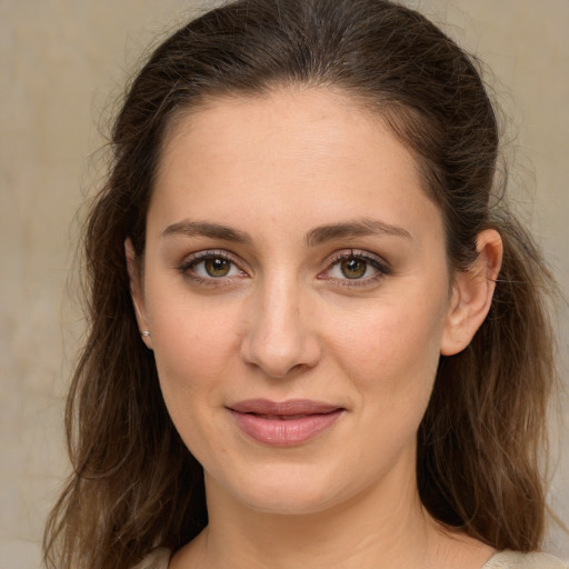 Joyful white young-adult female with long  brown hair and green eyes