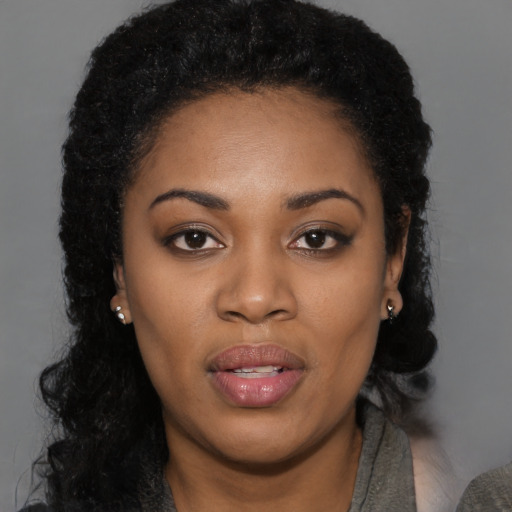 Joyful black young-adult female with medium  black hair and brown eyes