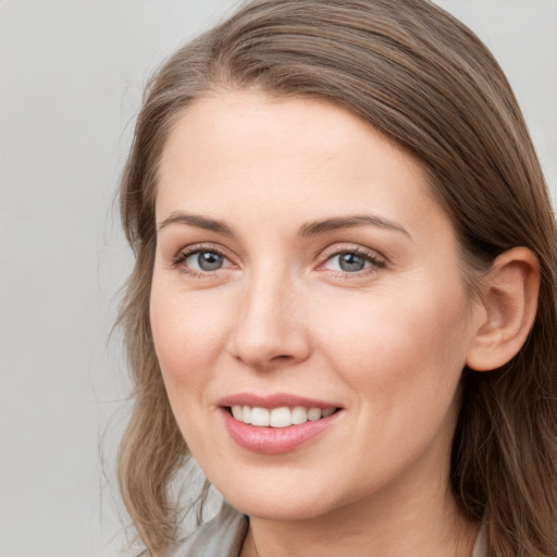 Joyful white young-adult female with long  brown hair and grey eyes