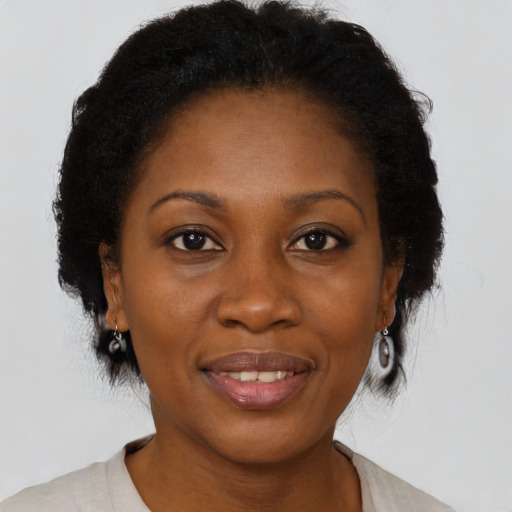 Joyful black adult female with medium  brown hair and brown eyes