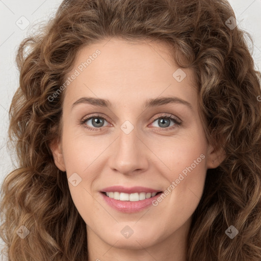 Joyful white young-adult female with long  brown hair and green eyes