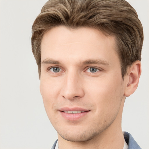 Joyful white young-adult male with short  brown hair and grey eyes