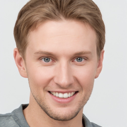 Joyful white young-adult male with short  brown hair and grey eyes