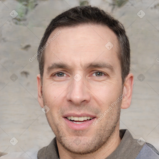 Joyful white adult male with short  brown hair and brown eyes