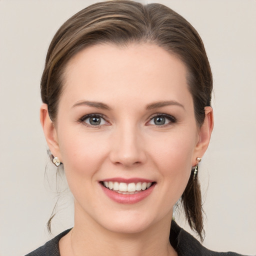 Joyful white young-adult female with medium  brown hair and grey eyes