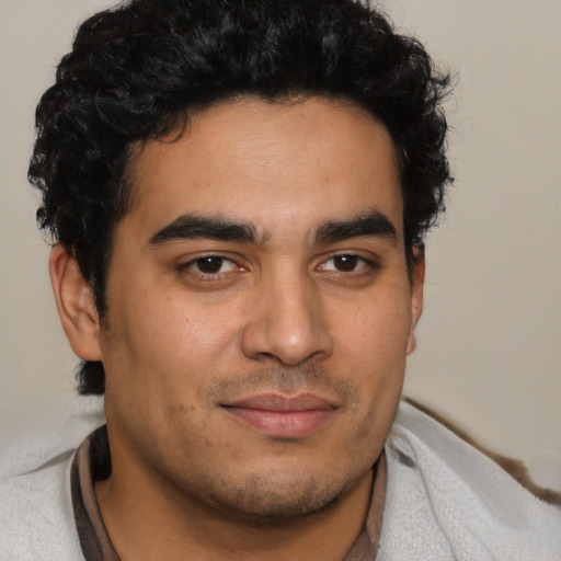 Joyful latino young-adult male with short  brown hair and brown eyes