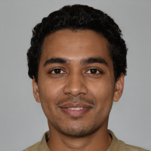 Joyful black young-adult male with short  black hair and brown eyes