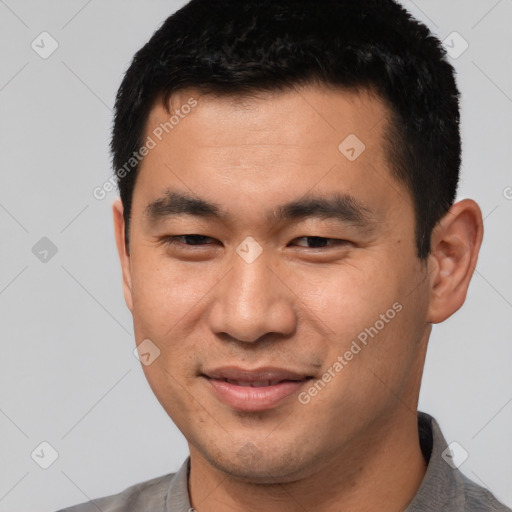 Joyful asian young-adult male with short  brown hair and brown eyes