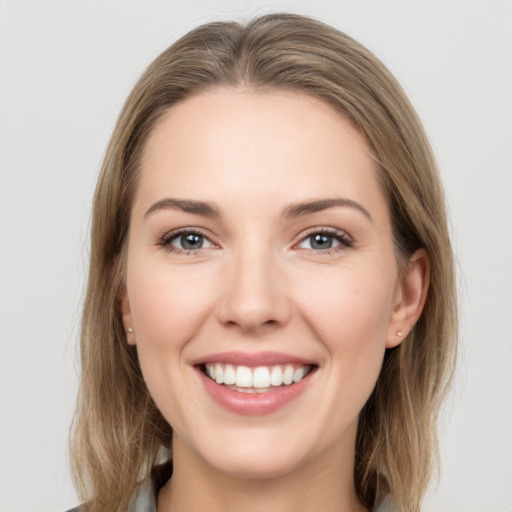 Joyful white young-adult female with long  brown hair and grey eyes