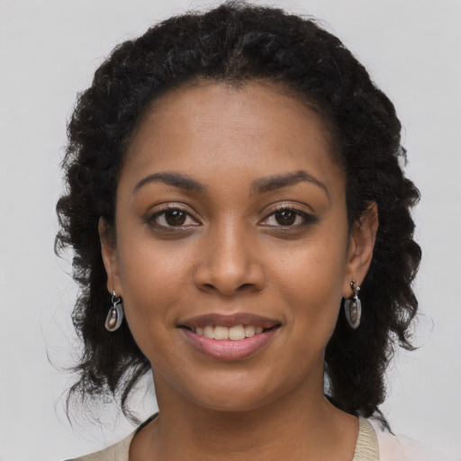 Joyful black young-adult female with long  black hair and brown eyes