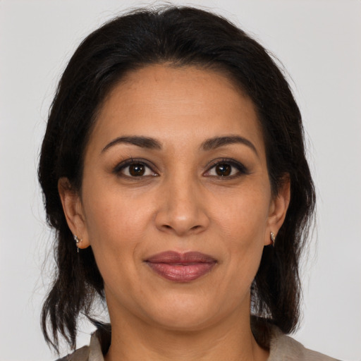 Joyful latino adult female with medium  brown hair and brown eyes