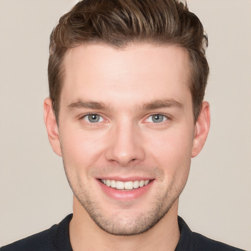 Joyful white young-adult male with short  brown hair and grey eyes