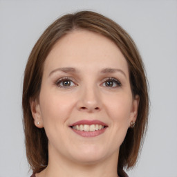 Joyful white young-adult female with medium  brown hair and grey eyes