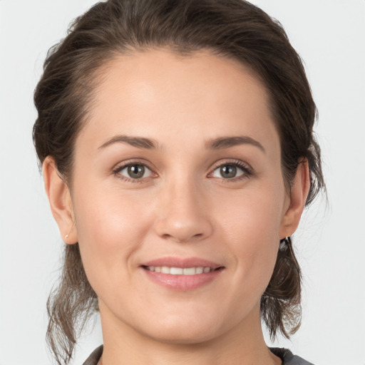 Joyful white young-adult female with medium  brown hair and grey eyes