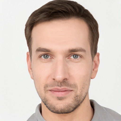 Joyful white young-adult male with short  brown hair and grey eyes