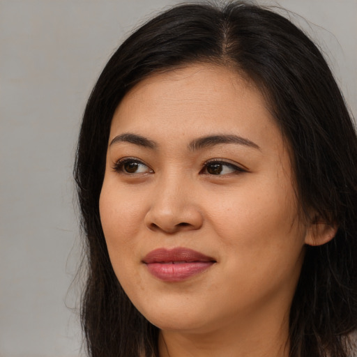 Joyful asian young-adult female with long  brown hair and brown eyes