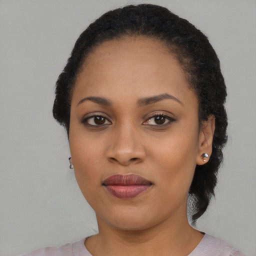 Joyful black young-adult female with long  black hair and brown eyes