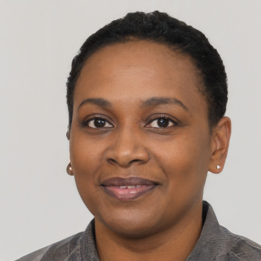 Joyful black young-adult female with short  black hair and brown eyes