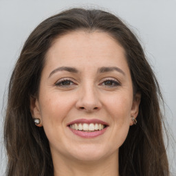 Joyful white adult female with long  brown hair and grey eyes