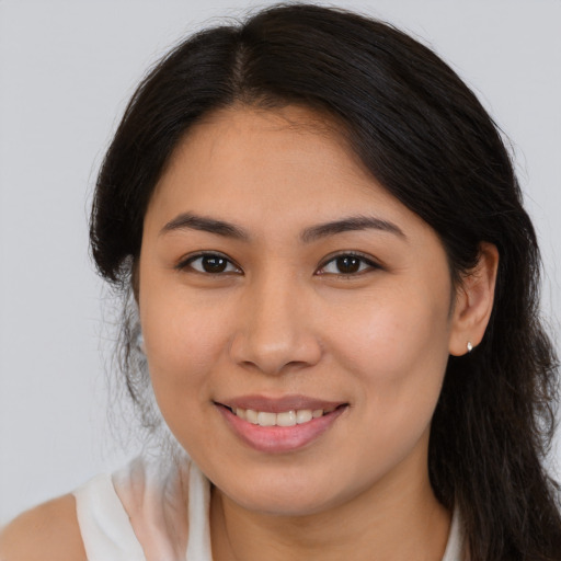 Joyful latino young-adult female with long  brown hair and brown eyes
