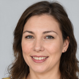 Joyful white adult female with long  brown hair and brown eyes