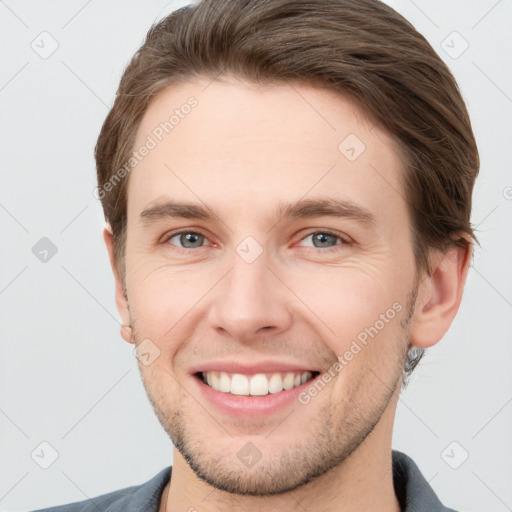 Joyful white young-adult male with short  brown hair and grey eyes