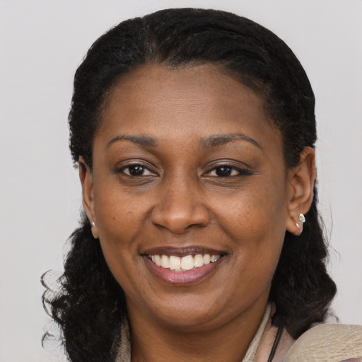 Joyful black adult female with long  brown hair and brown eyes