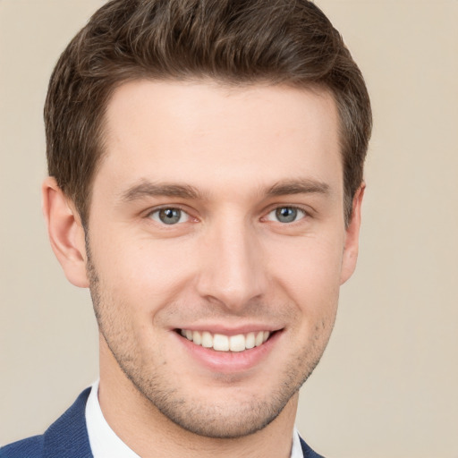 Joyful white young-adult male with short  brown hair and grey eyes