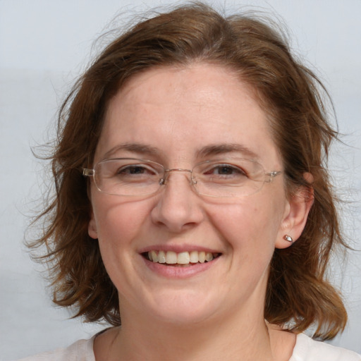 Joyful white adult female with medium  brown hair and blue eyes