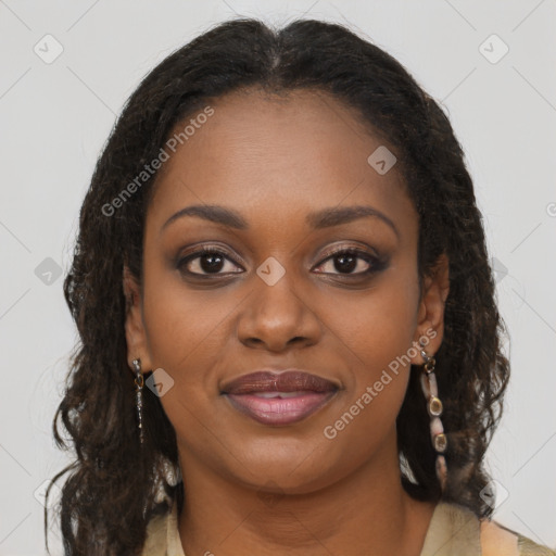 Joyful black young-adult female with long  brown hair and brown eyes