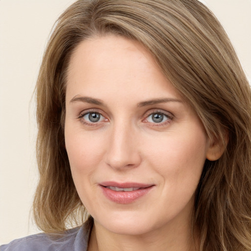 Joyful white young-adult female with long  brown hair and blue eyes