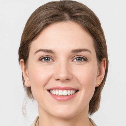 Joyful white young-adult female with medium  brown hair and grey eyes