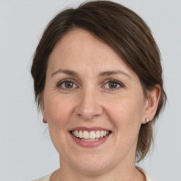 Joyful white adult female with medium  brown hair and grey eyes