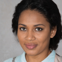 Joyful black adult female with medium  brown hair and brown eyes