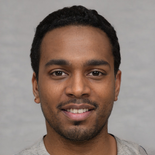 Joyful black young-adult male with short  black hair and brown eyes