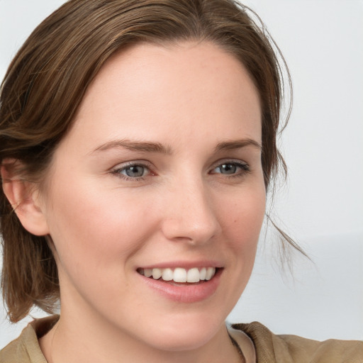 Joyful white young-adult female with medium  brown hair and blue eyes