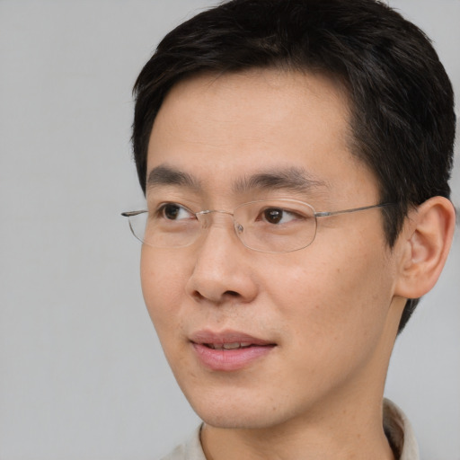 Joyful asian young-adult male with short  brown hair and brown eyes